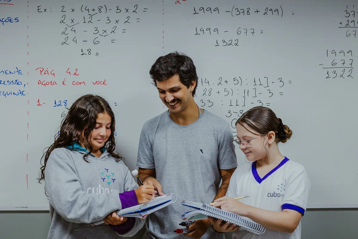 Professora acompanhando alunas em uma atividade acadêmica